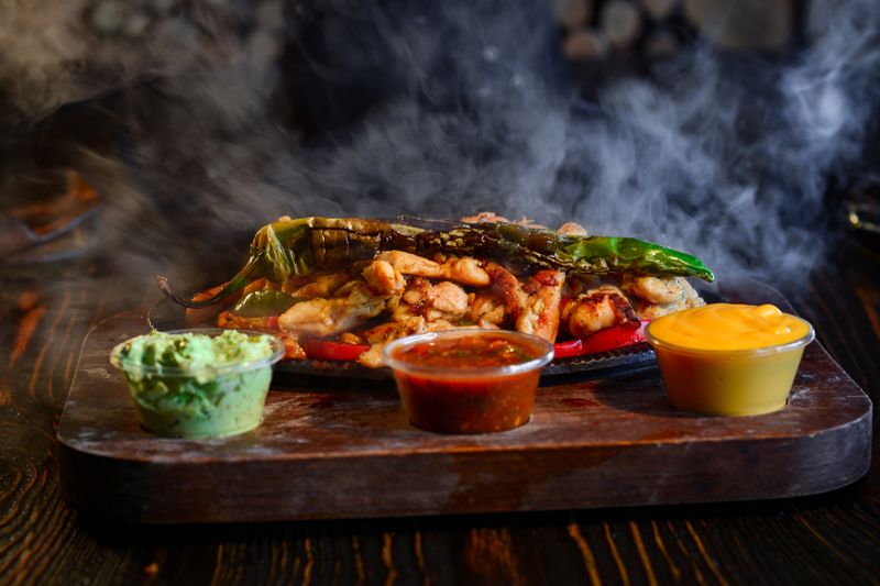 Beef and chicken fajitas with sizzling peppers and onions